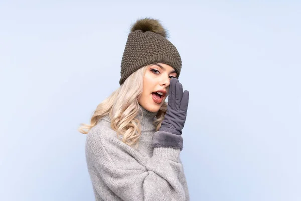 Junge Teenager Mädchen Mit Wintermütze Über Isoliertem Blauem Hintergrund Flüstert — Stockfoto