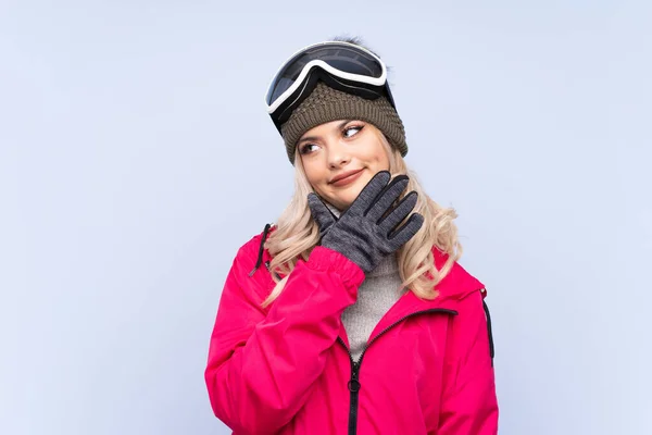 Sciatore Adolescente Ragazza Con Occhiali Snowboard Isolato Sfondo Blu Pensando — Foto Stock