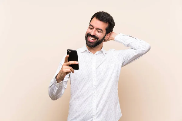 Junger Mann Mit Bart Der Ein Handy Hält Und Lächelt — Stockfoto