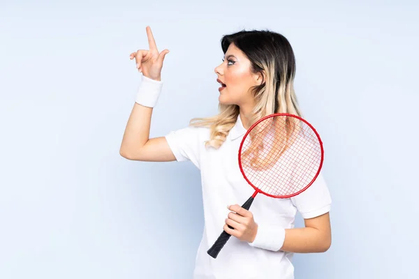 Adolescente Menina Jogando Badminton Isolado Fundo Azul Apontando Para Longe — Fotografia de Stock