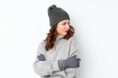 Kışlık şapkalı genç bir Rus kadın izole edilmiş beyaz arka planda bir fikir düşünüyor.