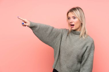 Soyutlanmış pembe arka planda genç sarışın Rus kadın.