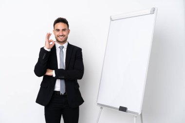 Young man giving a presentation on white board and showing ok sign with fingers