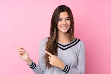 Soyutlanmış pembe arka planda genç bir kız işaret ediyor.