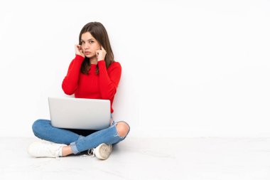 Polisle çalışan hassas kız, beyaz arka planda izole edilmiş, hayal kırıklığına uğramış ve kulaklarını kapatmış.