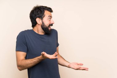 Sakallı ve yüzünde sürpriz ifade olan bir adam.