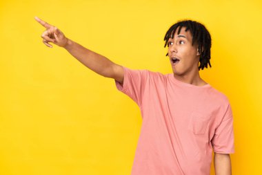 Sarı arka planda izole edilmiş genç Afrikalı Amerikalı adam