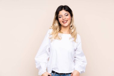 Bej arka planda izole edilmiş genç kız gülüyor.