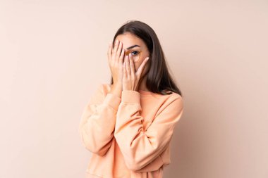 İzole edilmiş bir geçmişi olan genç bir kız, gözleri kapatıyor ve parmaklarından bakıyor.