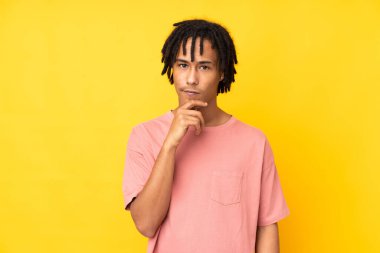 Genç Afrikalı Amerikalı adam sarı arka planda izole edilmiş.