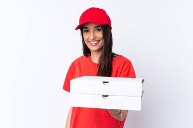 Pizza dağıtan kadın, izole edilmiş beyaz duvarın üzerinde mutlu bir ifadeyle pizza tutuyor.