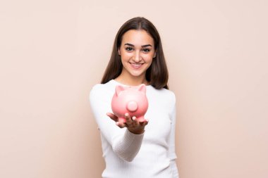 Tecrit edilmiş genç bir kadın elinde büyük bir kumbara tutuyor.