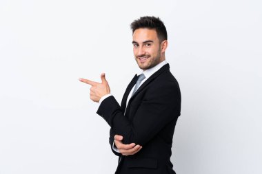 Young business man over isolated background pointing finger to the side