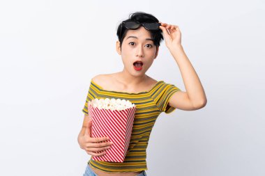 Genç Asyalı kız 3D gözlüklü ve elinde koca bir kova patlamış mısırla şaşırdı.