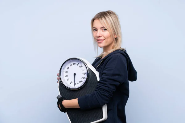 Jonge Sport Blonde Vrouw Geïsoleerde Blauwe Achtergrond Met Weegmachine — Stockfoto