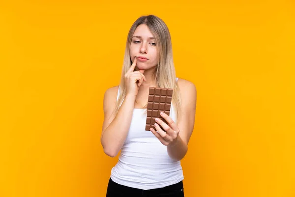 Mladá Blondýna Žena Přes Izolované Modré Pozadí Čokoládovou Tabletu Mají — Stock fotografie
