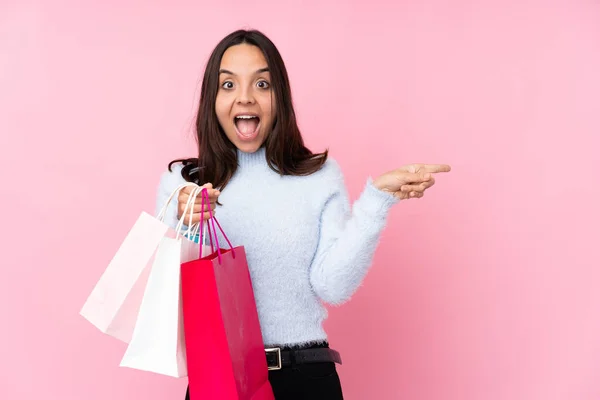 Giovane Donna Con Shopping Bag Sfondo Rosa Isolato Sorpreso Indicando — Foto Stock