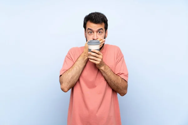 Młody Człowiek Brodą Trzymający Kawę Wyizolowanym Niebieskim Tle Pokrywającym Usta — Zdjęcie stockowe