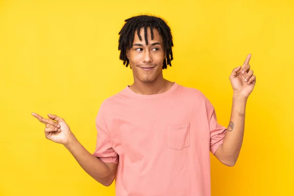 Mladý Africký Američan Izolovaný Žlutém Pozadí Ukazující Prstem Laterály Šťastný — Stock fotografie