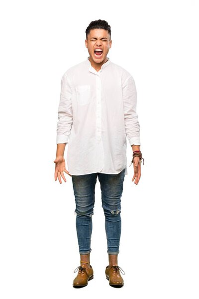 A full-length shot of a Young man shouting to the front with mouth wide open over isolated white background