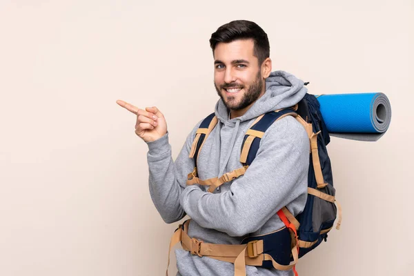 Ung Bergsklättrare Man Med Stor Ryggsäck Över Isolerad Bakgrund Pekar — Stockfoto