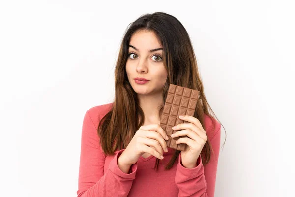 Mladá Běloška Žena Izolované Růžovém Pozadí Čokoládovou Tabletu Mají Pochybnosti — Stock fotografie