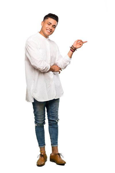 A full-length shot of a Young man pointing finger to the side over isolated white background