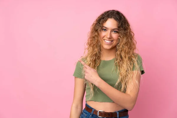 Mulher Loira Jovem Com Cabelo Encaracolado Isolado Fundo Rosa Apontando — Fotografia de Stock