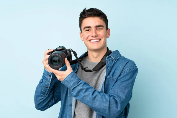 Adolescente fotógrafo hombre aislado sobre fondo azul —  Fotos de Stock