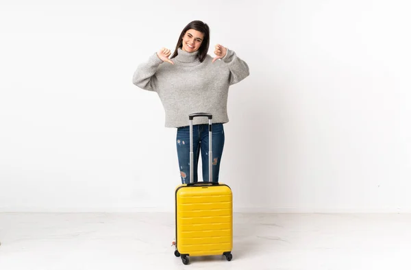独立した白い壁の上にスーツケースを持つ旅行者の女性の完全な長さの体誇りと自己満足 — ストック写真