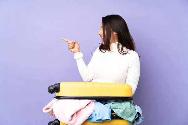 Viaggiatore Giovane Donna Con Una Valigia Piena Vestiti Sfondo Viola — Foto Stock