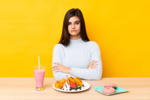 Mujer Joven Comiendo Gofres Batido Una Mesa Sobre Fondo Amarillo —  Fotos de Stock