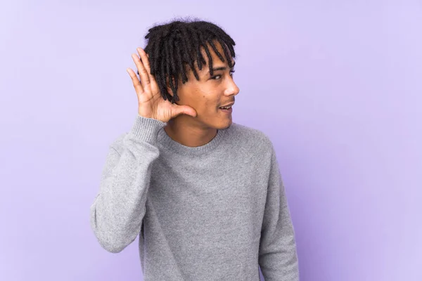 Joven Afroamericano Aislado Sobre Fondo Púrpura Escuchando Algo Poniendo Mano — Foto de Stock