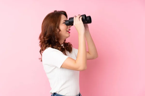 Jovem Mulher Russa Sobre Fundo Rosa Isolado Com Binóculos Pretos — Fotografia de Stock