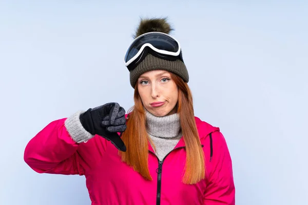 Lyžařka Ryšavá Žena Snowboardovými Brýlemi Přes Izolovanou Modrou Zeď Ukazující — Stock fotografie