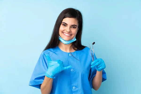 Młoda Kobieta Dentysta Trzyma Narzędzia Odizolowanym Tle Niebieski Gest Telefonu — Zdjęcie stockowe