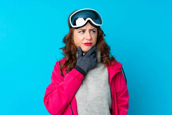 Skier Kobieta Okularach Snowboardowych Odizolowanej Niebieskiej Ścianie Myśląc Pomysł — Zdjęcie stockowe
