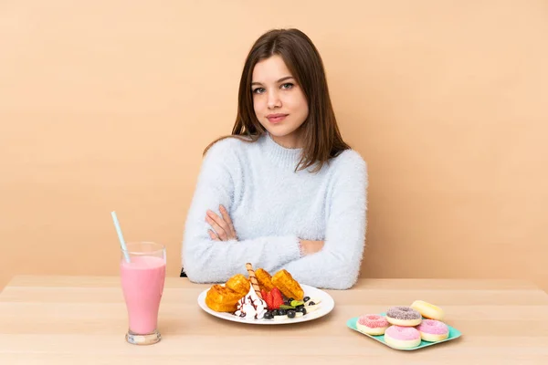 Chica Adolescente Comiendo Gofres Aislados Sobre Fondo Beige Manteniendo Los —  Fotos de Stock
