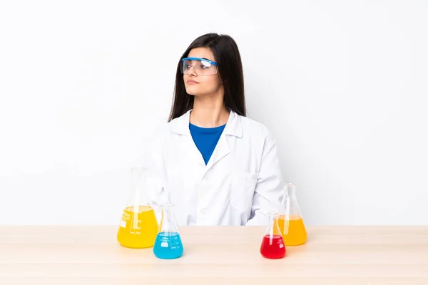 Νεαρή Επιστημονική Γυναίκα Ένα Τραπέζι Κάνοντας Χειρονομία Αμφιβολιών Αναζητούν Πλευρά — Φωτογραφία Αρχείου