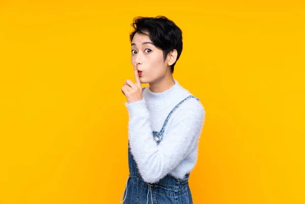 Young Asian Girl Overalls Isolated Yellow Background Doing Silence Gesture — 스톡 사진