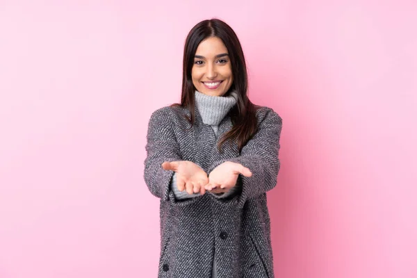 Joven Morena Sobre Fondo Rosa Aislado Sosteniendo Espacio Copia Imaginario — Foto de Stock