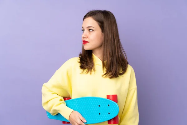 Tiener Meisje Geïsoleerd Paarse Achtergrond Met Een Skate — Stockfoto