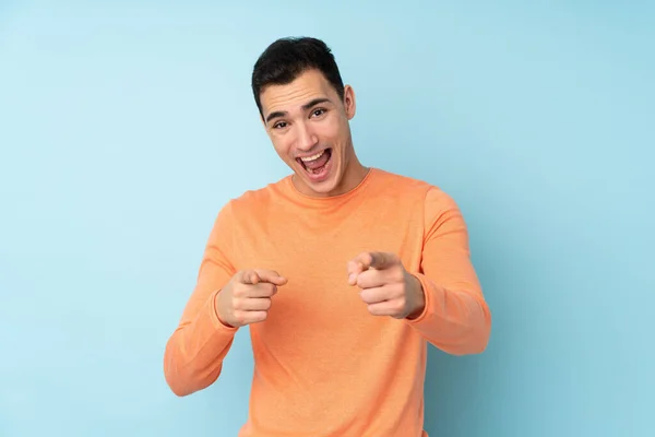 Mladý Kavkazský Pohledný Muž Izolovaný Modrém Pozadí Ukazuje Dopředu Usmívá — Stock fotografie