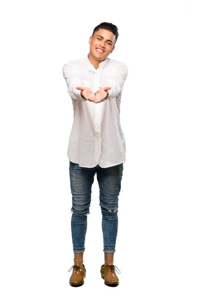 A full-length shot of a Young man holding copyspace imaginary on the palm to insert an ad over isolated white background