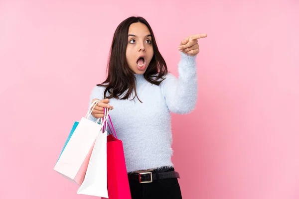 Junge Frau Mit Einkaufstasche Über Isoliertem Rosa Hintergrund Zeigt Weg — Stockfoto