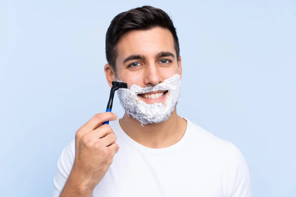 Jovem bonito homem barbear sua barba sobre fundo isolado — Fotografia de Stock