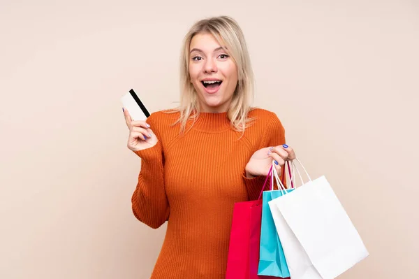 Junge Blonde Frau Über Isolierten Hintergrund Mit Einkaufstüten Und Überrascht — Stockfoto