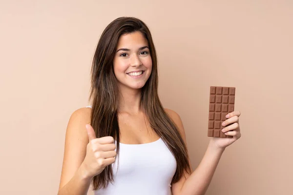 Teenager Dívka Přes Izolované Pozadí Čokoládovou Tabletu Palcem Nahoru — Stock fotografie