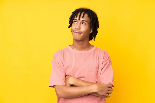 Jovem Afro Americano Isolado Fundo Amarelo Olhando Para Cima Enquanto — Fotografia de Stock