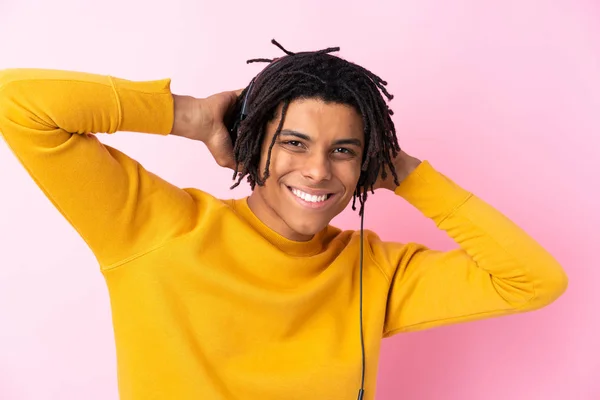 Joven afroamericano escuchando música sobre aislado rosa wa — Foto de Stock